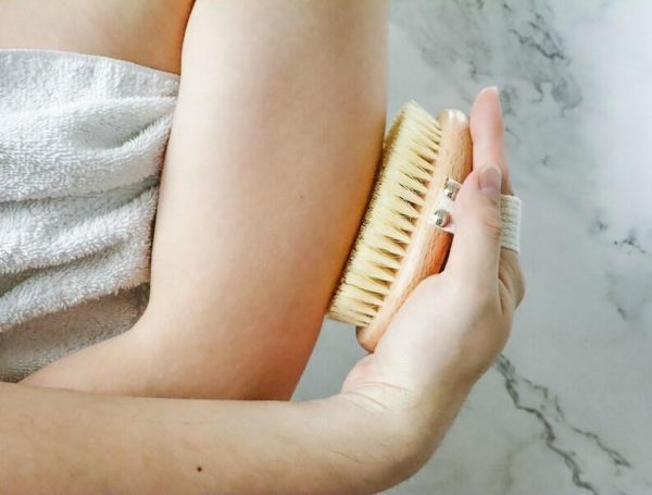 Plantish Future Beauty and Bathroom - person using dry body  brush on upper arm